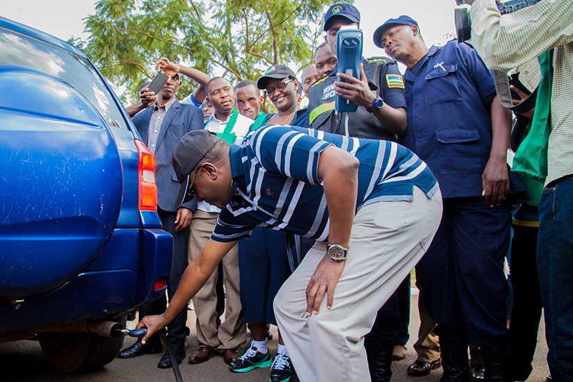 Dr Biruta tests levels of carbon emissions from a car as police officers verify if the results match with the environmental standards. / File