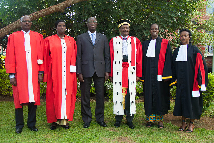 Prime Minister Anastase Murekezi and Prosecutor-General Richard Muhumuza (C) poses for a photo with the new prosecutors. / Nadege Imbabazi