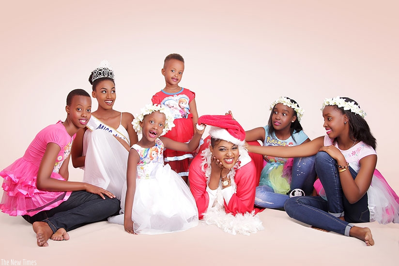 Miss Naiades 2016 Peace Kwizera Ndaruhutse (with crown) and gospel singer Aline Gahongayire, pose for a photo with some of the kids who will take part in the Christmas Kids festival. / Donata Kiiza