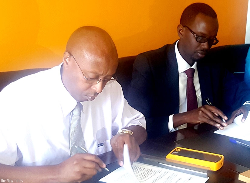 Nyagahene (left) and Barera sign the partnership deal at MobiCash offices in Gishushu. E-payment facilities, like POS, are supporting job-creation efforts. (Photos by Frederic Byumvuhore)