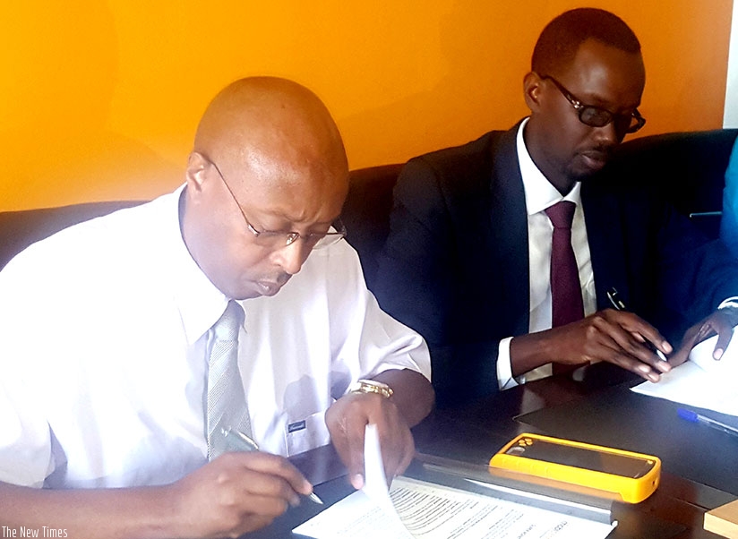 Nyagahene (left) and Barera sign the partnership deal at MobiCash offices in Gishushu. E-payment facilities, like POS, are supporting job-creation efforts. (Photos by Frederic Byumvuhore)