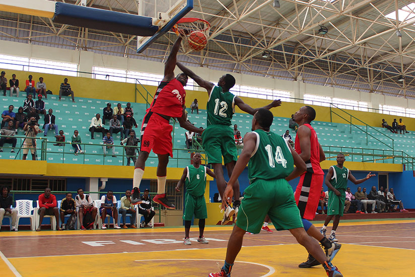 REG centre player Bievenue Ngandu goes for a slam as Rusizi players try to block him during third quarter on Sunday. REG won the game 93-65. / Courtesy