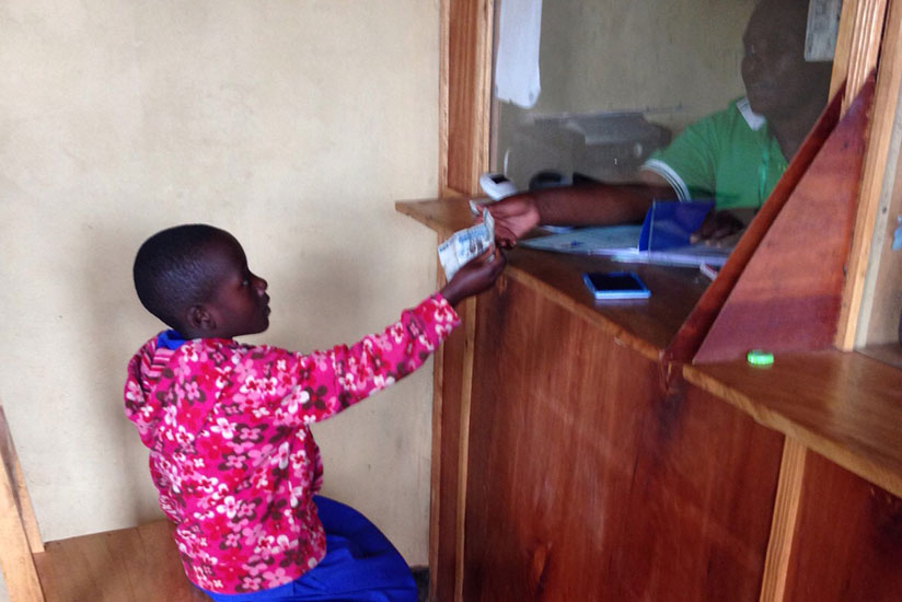 A primary school pupil deposits her savings at a microfinance bank. It is crucial to inculcate a savings culture among children. / File