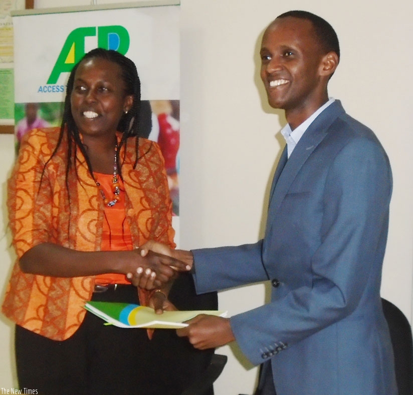Kibe (left) and Ntare exchange documents after signing the grant deal. / (Triphomus Muyagu)