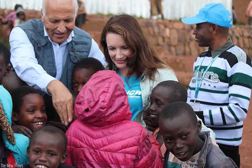 Azam (L) and Davis share a light moment with Burundian refugee children at Mahama camp. (Moses Opobo)