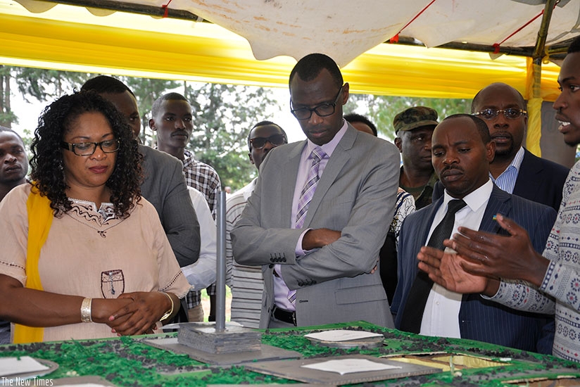 An exhibitor explains to MP Agnes Mukazibera (L) and Minister Musafiri (C) a concept at Ines Ruhengeri on Tuesday. (Frederic Byumvuhore)