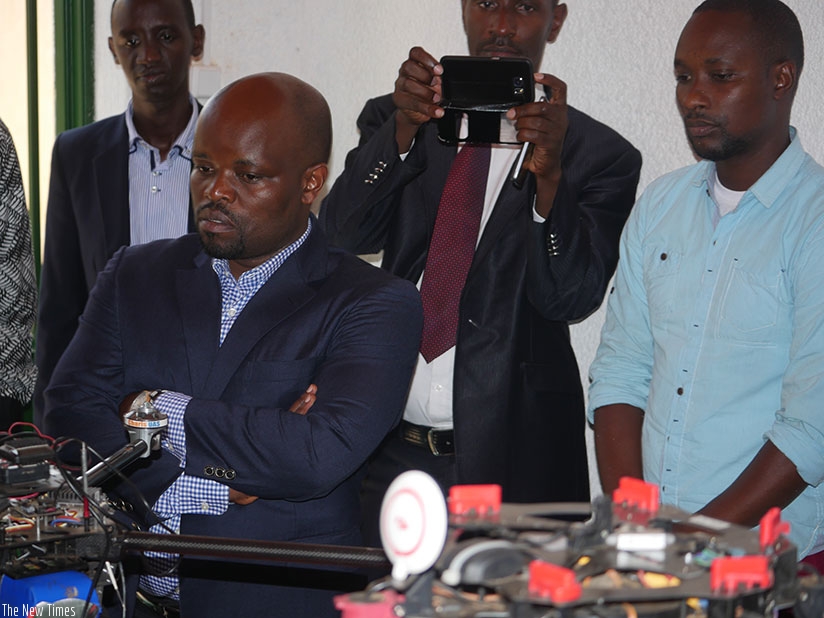 Minister Nsengimana (L) follows a demonstration of how the drone operates. (Photos by Frederic Byumvuhore)