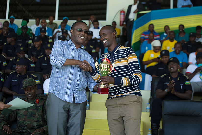 Minister for Natural Resources Dr. Vincent Biruta (L) gives a trophy to Gasabo Mayor Steven Rwamurangwa after the district emerged as the best winner in Security and hygiene campai....