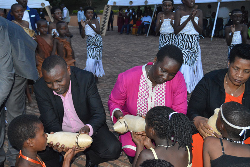 State Minister for primary and secondary education Isaac Munyakazi, Minister Julienne Uwacu and Southern Province governor Marie-Rose Mureshyankwano serve milk to children. / John Mbaraga