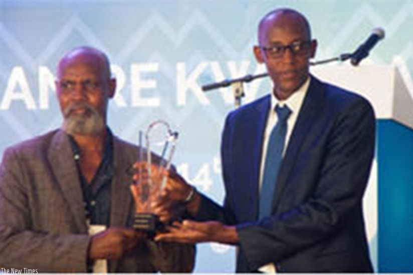 Munyemana receives the Made-in-Rwanda 2016 expo Best Handicraft Exhibitor Award from Stephen Ruzibiza, the PSF chief executive.  ( All photos by Nadege Imbabazi.)