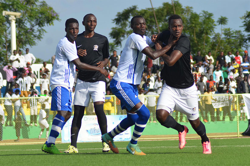 Pepiniere FC players (in white and blue) against APR players (in black and white) during a previous league game at Kigali Regional Stadium. / Sam Ngendahimana
