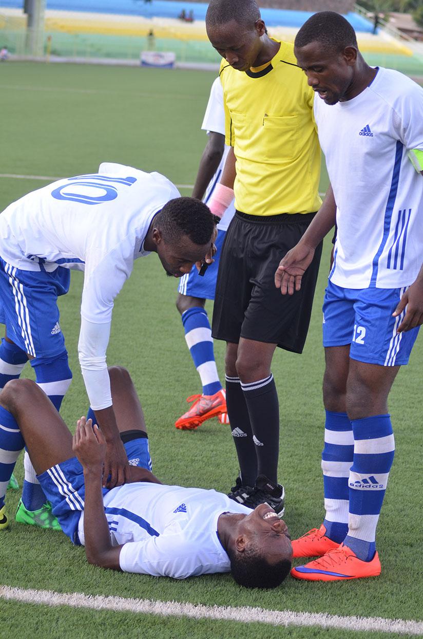 DOWN AND OUT: Pepiniere FC's two high profile players Kevin Ishimwe (L) and captain Omar Hitimana (R) paying attention to an injured teammate during the game against APR FC early t....