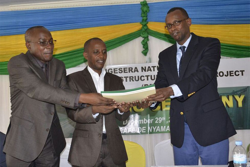 PS Kayisinga (R) and Dr Ngarambe (L) hand over the project file to Mayor Nsanzumuhire as a sign that the project activities now belong to the district. / Emmanuel Ntirenganya