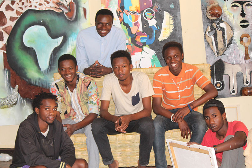 The artists pose in front of some of their works.