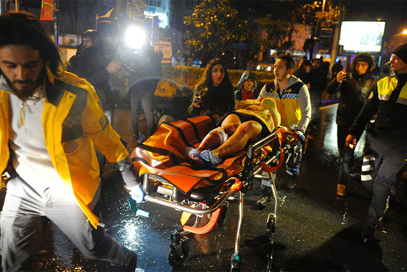 Paramedics carry an injured woman from the site of a mass shooting at an Istanbul nightclub. / Photograph: Ihlas News Agency/AFP/Getty Images