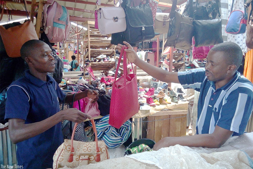 Hagenimana (left), a member of Twambutsanye Co-operative, bargains with a client. (Appolonia Uwanziga)