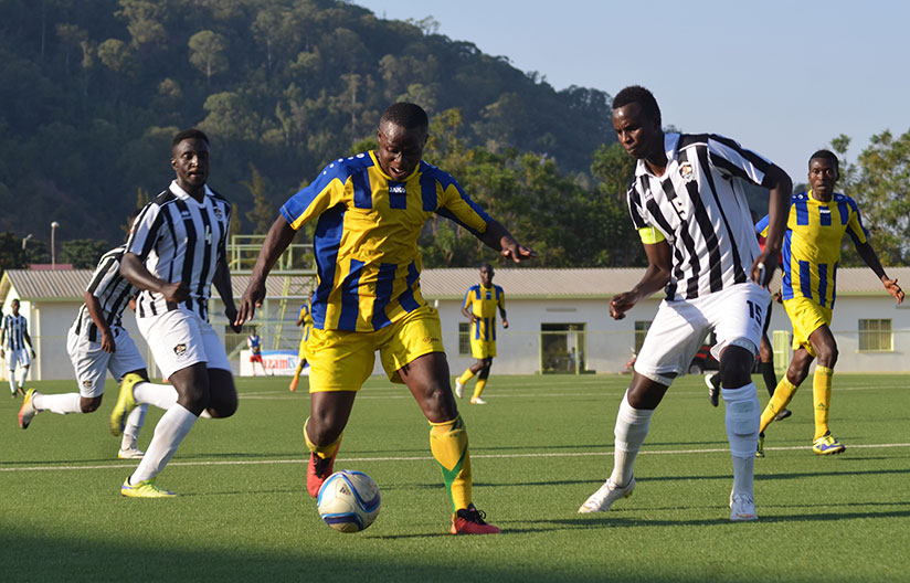 AS Kigali striker Michel Ndahinduka runs passed APR FC defender Faustin Usengimana (R) and Herve Rugwiro during the match at Kigali Regional Stadium. / Sam Ngendahimana