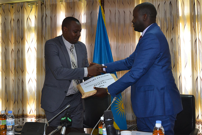Isaac Munyakazi, the minister of state for primary and secondary education receives PLE results from Janvier Gasana of Rwanda Education Board this morning in Kacyiru. (Jean d'Amour....