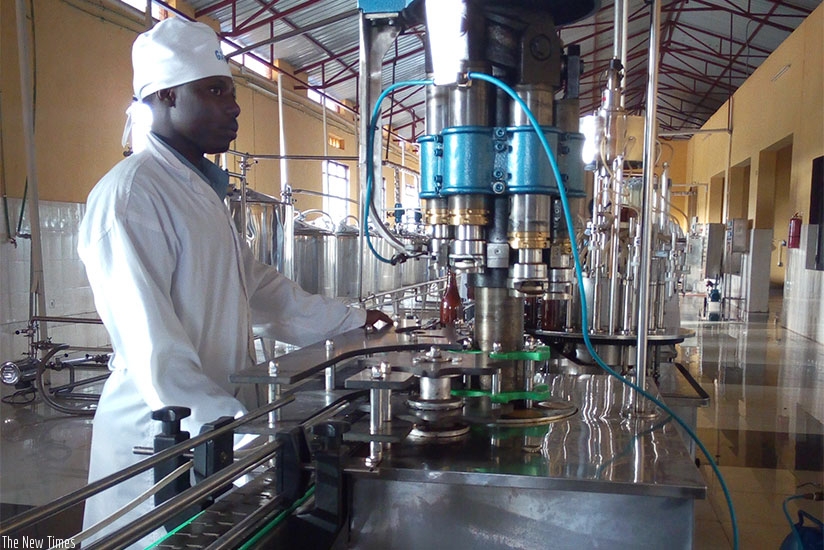 An employ of Gisagara Agro Business Industry monitors the production line at the factory. / Appolonia Uwanziga.  