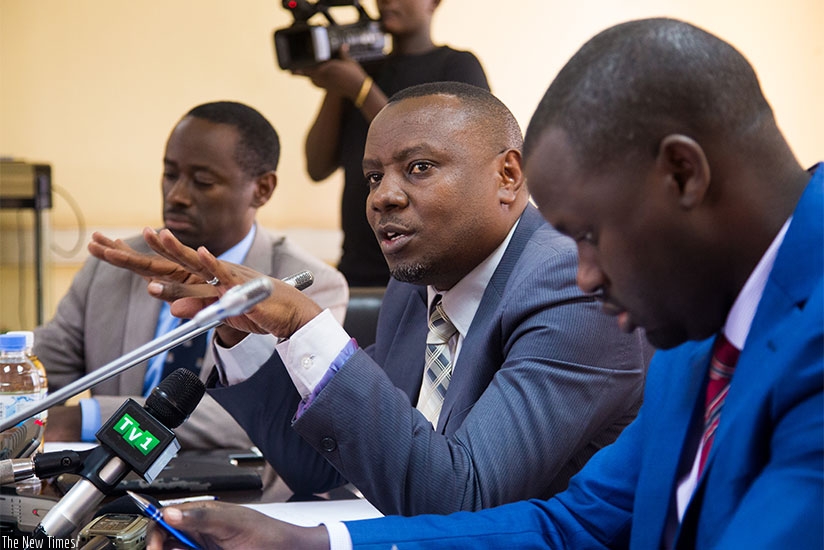 Isaac Munyakazi, the minister of state for primary and secondary education (C) speaks to media during the press conference as Janvier Gasana of Rwanda Education Board looks on. Fau....