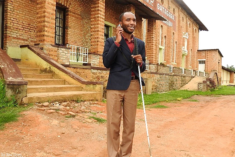 Vuguziga speaks on phone. Visual impairment has not stopped the ICT enthusiast from achieving his dreams and he keeps dreaming to do more for people with visual impairments like hi....