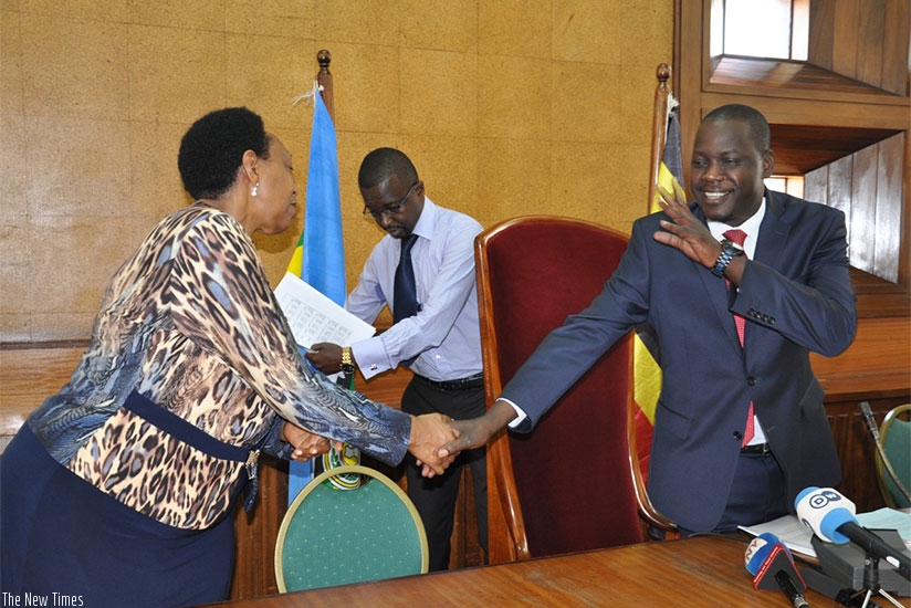 EALA Speaker Dan Kidega (R) chats with EALA member from Rwanda Patricia Hajabakiga after the news conference in Kampala yesterday. Courtesy.