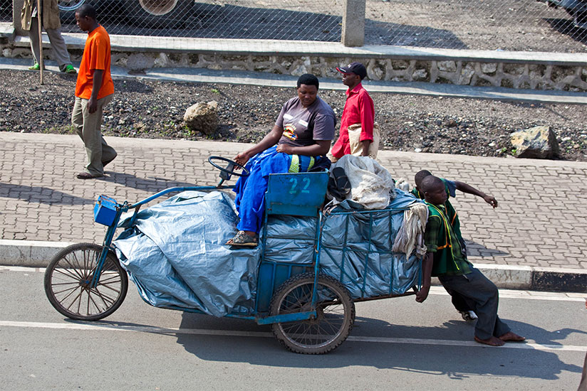 A businesswoman sits on a cart transporting goods from DR Congo to Rubavu. / Timothy Kisambira