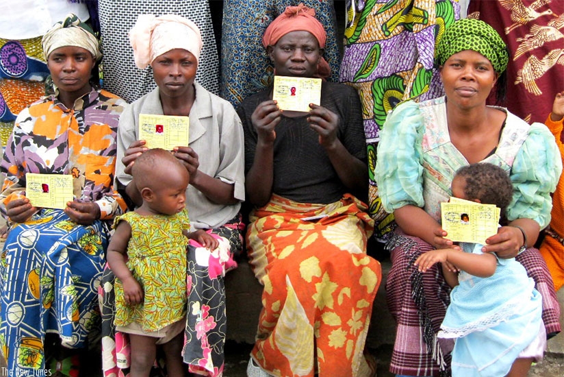 Mothers  pose in a group photo with their Mutuelle de Sante cards. File.