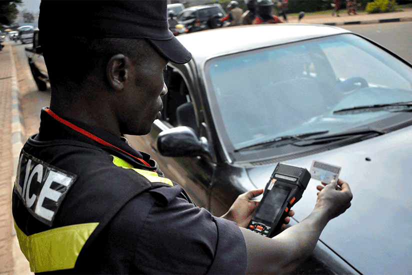 A traffic officer scanning a  driver's license of an offender using a Hand Held Terminal. (Courtesy)