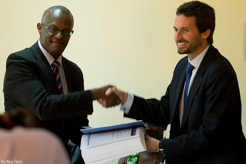 Dr Emile Rwamasirabo, the chief executive of King Faisal Hospital (L) hands over documents to Carlos Malet OSHEN HEALTH CARE managing director yesterday. T 