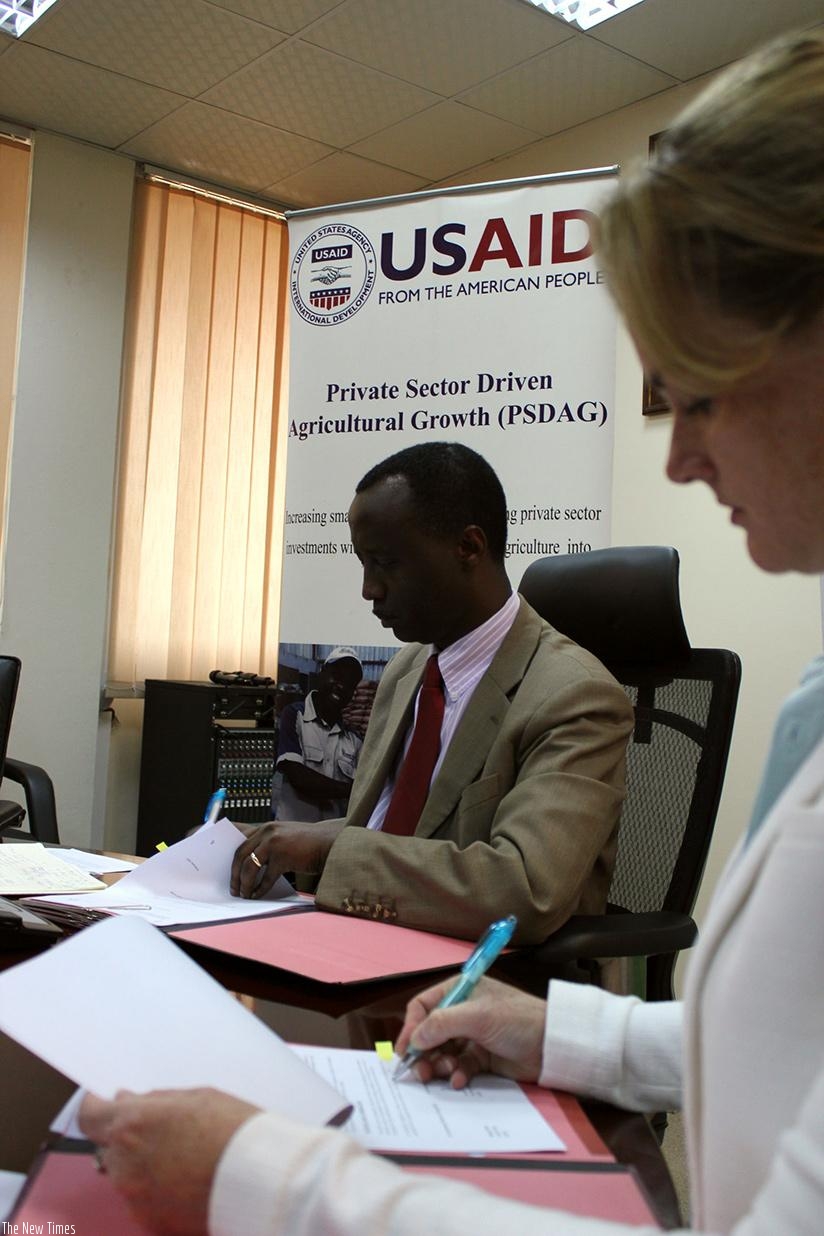 Alex Kanyankole and Melanie Bittle sign the Memorandum of Understanding. (Donata Kiiza)