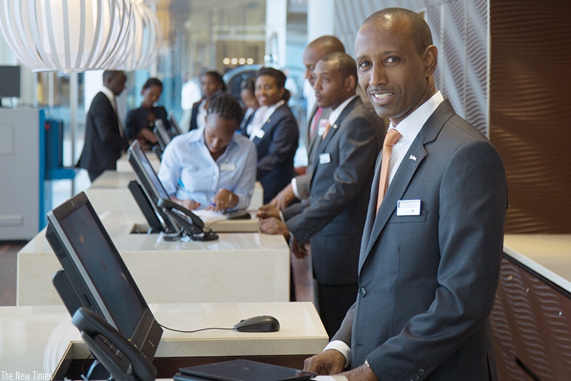 Front desk staff at Radisson Blu Hotel attend to customers. Hospitality sector players say they are ready to host the forthcoming Africa aviation summit. / T. Kisambira.
