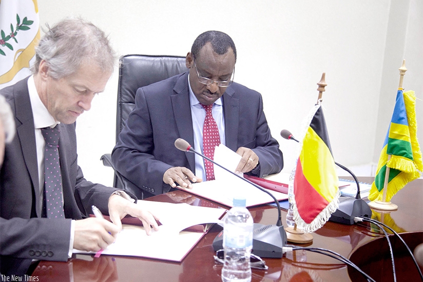The Minister for Finance and Economic Planning, Claver Gatete (R) signs documents with Arnout Pauwels, the Belgium Ambassador to Rwanda, yesterday in Kigali. Sam Ngendahimana.