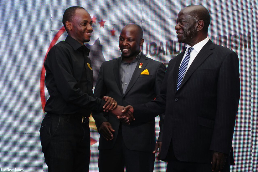 Philbert Ndandali (left) from RDB is congratulated by Uganda's Vice President Edward Kiwanuka Sekandi (right) as Godfrey Kiwanda, Uganda's State Minister for Tourism looks on.  RDB....