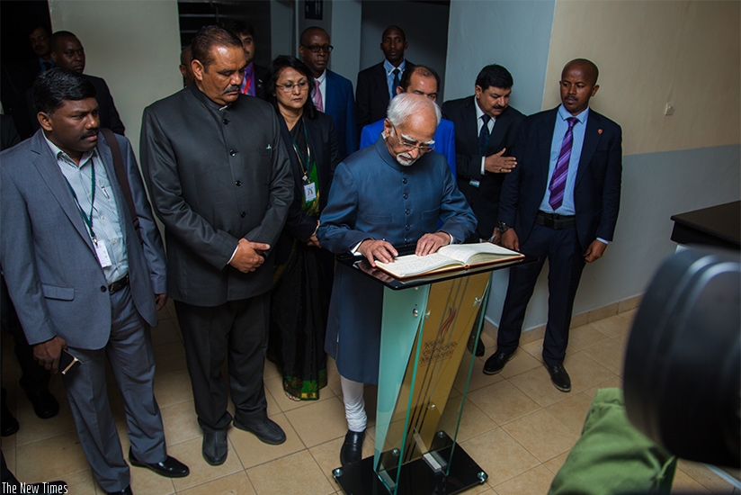Ansari writes a message in the visitors' book at Kigali Genocide Memorial Centre.  (Faustin Niyigena)