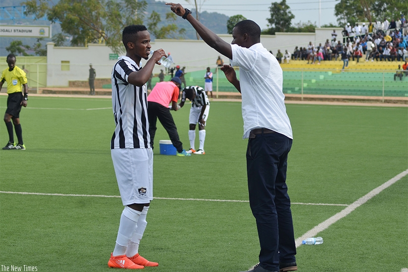 Mulisa gives instructions to midfield playmaker Yannick Mukunzi during a recent league match at Kigali Regional Stadium. (Sam Ngendahimana)