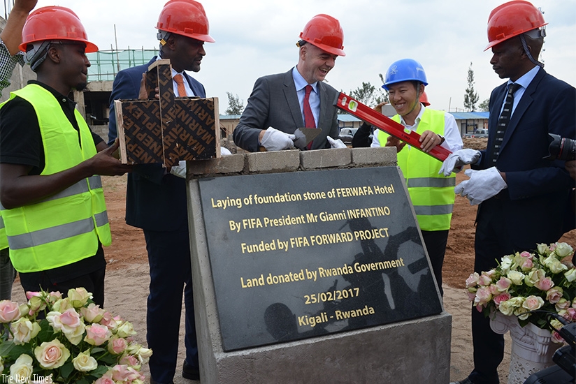 FIFA President Gianni Infantino (C), flanked by FERWAFA boss Vincent Nzamwita (L) and Permanent Secretary in the Ministry of Sports and Culture, Lt. Col. Patrice Rutagambwa (R), la....