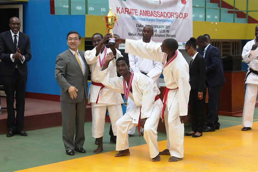 Maramu lifts his trophy aloft. Left is Amb. Miyashita. Jejje Muhinde