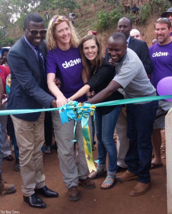 Antoine Bisizi (L), Brooke Sergeberg (2nd Right) and other officials cut a ribbon at the launch of the bridge. John Mbaraga. File.