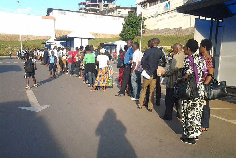 Passengers queue as they wait for buses at the taxi park in downtown Kigali. Ange Violette Iradukunda. (File)