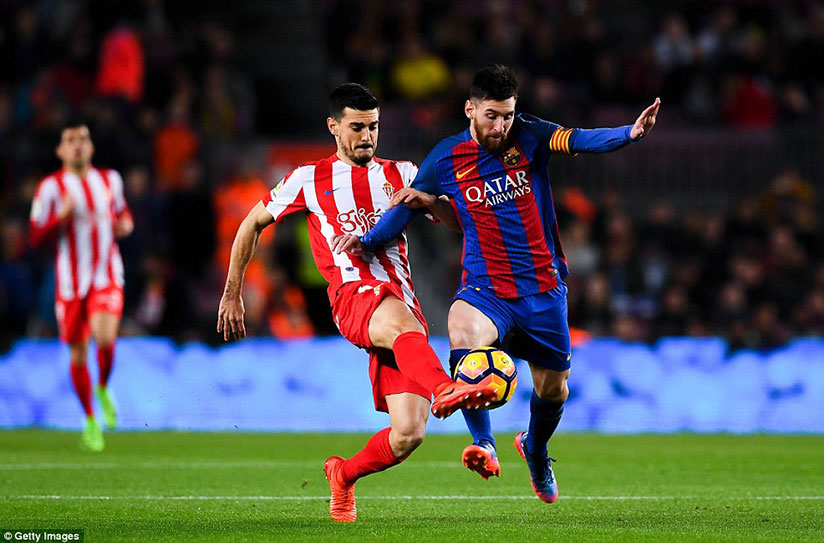 Messi competes for the ball with Sergio Alvarez as Barcelona ended the game as a contest inside 10 minutes with two goals. / Getty Images