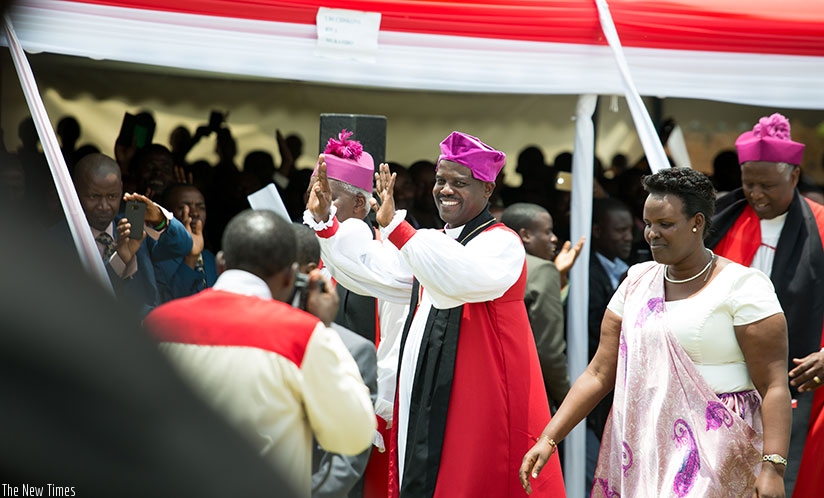 New Anglican bishop Mugiraneza (C) waves to the congregation after his consecration yesterday. Timothy Kisambira.