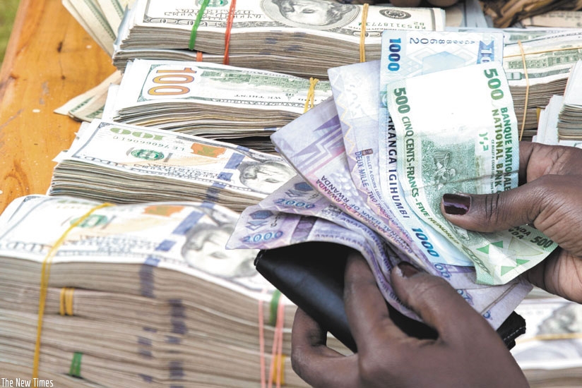 A client counts money after a transaction at downtown forex bureau. / File.