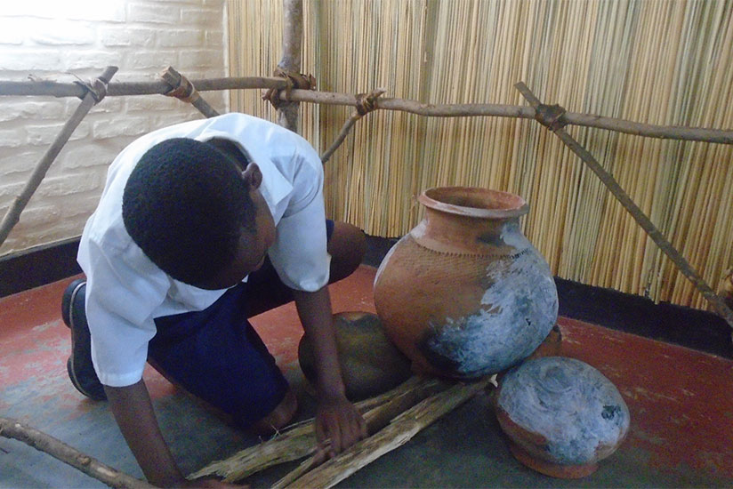 A pupil demonstrates how food was prepared in the past. / Lydia Atieno