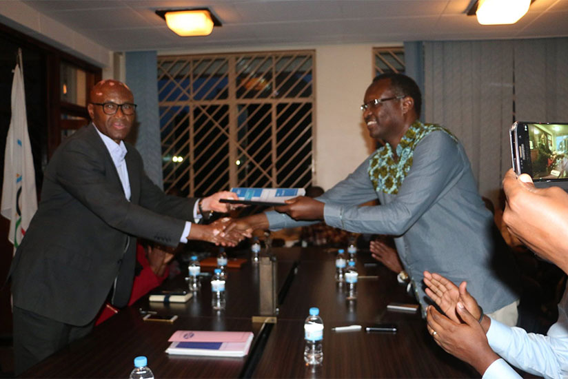 Outgoing RNOSC president Bayigamba (R) officially hands over office to his successor Amb. Munyabagisha on Tuesday. / Jejje Muhinde
