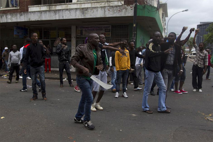 A group of South African men with machetes and sticks attacking foreigners. The country has gappled with xenophobic attacks in the recent past. / Internet photo