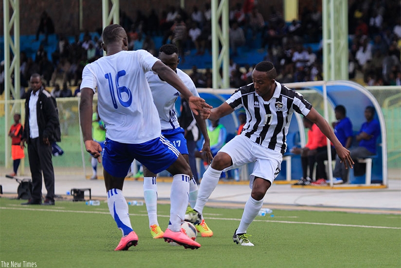 APR's Maxime Sekamana (R) controls the ball against Pepiniere's players yesterday. Sam Ngendahimana.