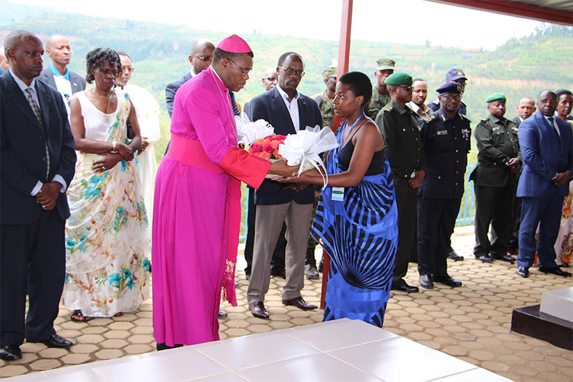Bishop Anaclet Mwumvaneza receives a wreath to lay on the tomb of Nyange Secondary School students in Ngororero District yesterday. The students, who are all national heroes recogn....