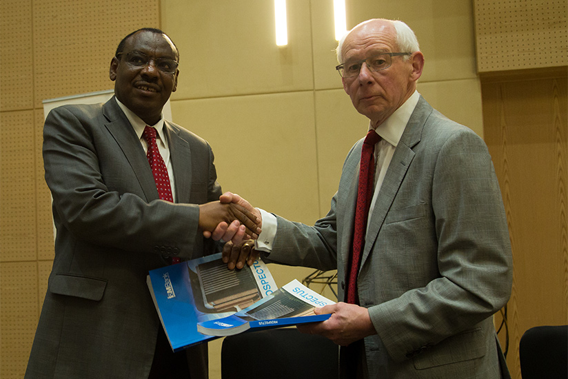Finance and Economic Planning minister Claver Gatete exchanges documents with I&M Bank board chairperson Bill Irwin during the Initial Public Offering for the bank in Kigali last month.