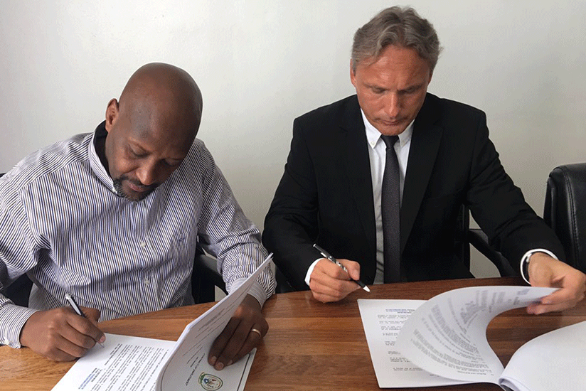 Antoine Hey (R) signing the contract bidding him as a Amavubi head coach for the next one year alongside FERWAFA President Vincent Nzamwita. Courtsey photo.